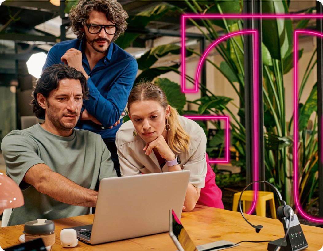 Zwei Männer und eine Frau informieren sich am Laptop über die Glasfaser-Produkte für Geschäftskunden der Telekom